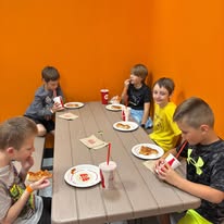 Kids enjoying pizza during a birthday party at Arena 5/9