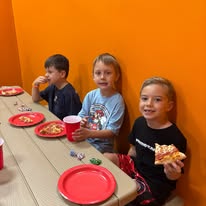 Children eating pizza at an Arena 5/9 birthday party